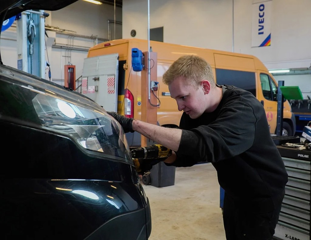 Mekaniker udfører service på motoren i en IVECO Daily på autoriseret værksted